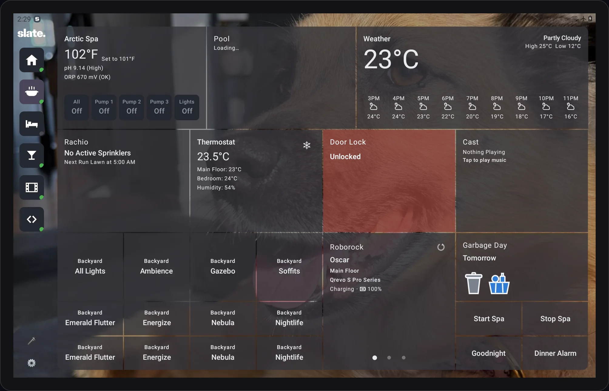 Slate's kitchen wall panel, screenshotted from a live tablet: hot tub, pool, weather, sprinklers, thermostat, door lock, music, backyard lighting scenes, the vacuum, garbage day and house scenes, over a photo of the dog